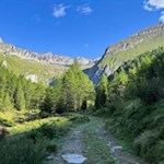 Der Wanderweg zum Eisbruggsee wird von hochaufragenden Felsen umrahmt