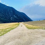 Der Feldweg führt durch weite Felder