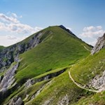 Von der Dreifingerscharte windet sich der Steig über steile Grashänge zur Hochalmhütte Fojedöra 