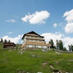 Inmitten-einer-blumenfrohen-Wiese-liegt-die-stattliche-Gardenacia-Hütte